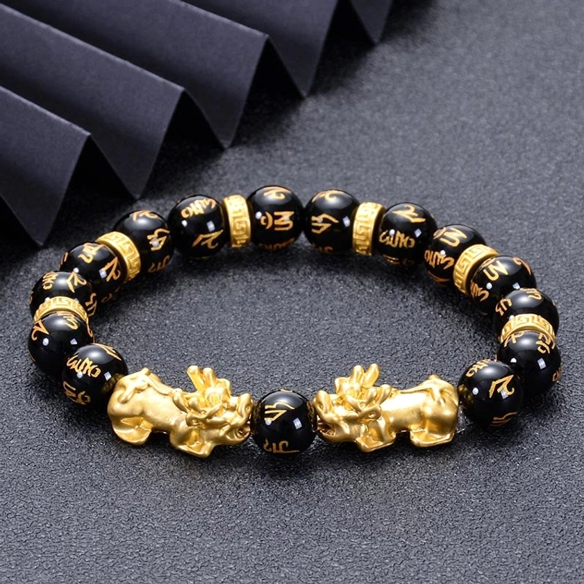 Double Pixiu Buddhist protection bracelet flat lay with black onyx beads and gold accents