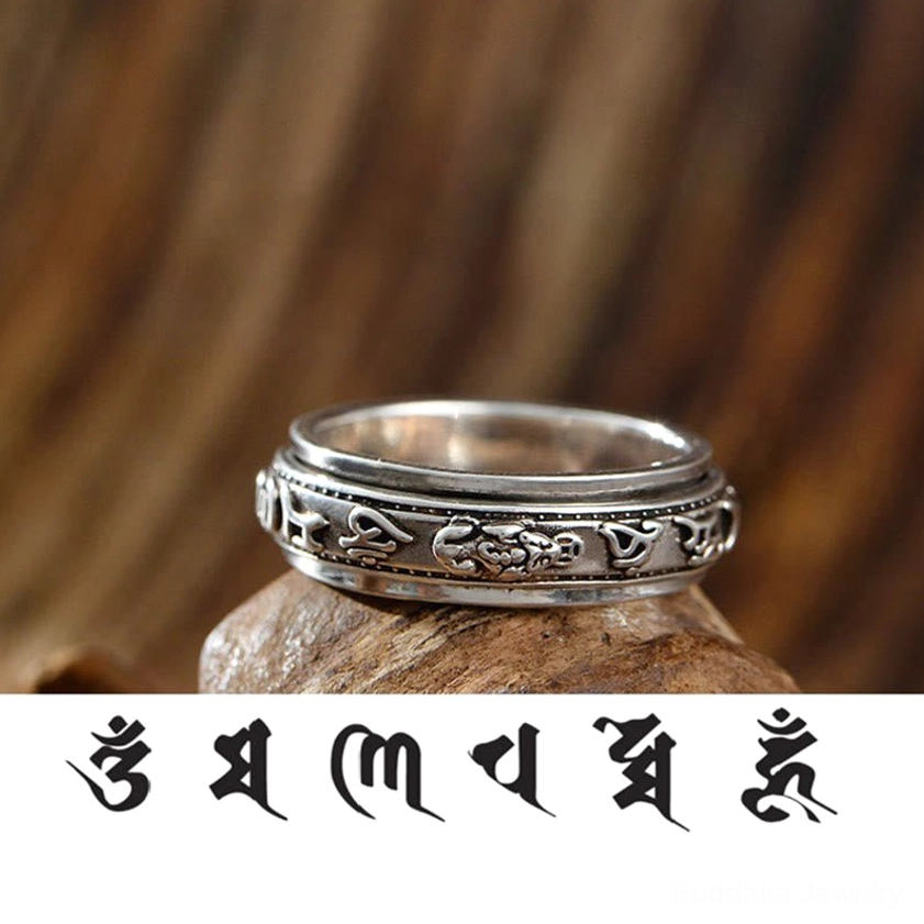 Low side close-up of Tibetan mantra rotating ring featuring carved PiXiu and Om Mani Padme Hum script with antique silver patina