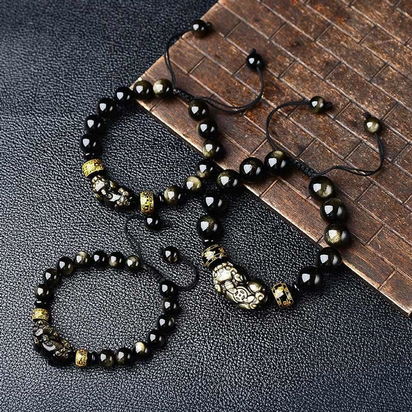 Multiple gold sheen obsidian Pixiu Buddhist bracelets displayed together, demonstrating the wealth protection set with adjustable pull knots