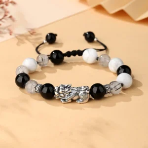 Pixiu prosperity bracelet with Om Mani Padme Hum mantra, 999 sterling silver charm with black obsidian and white turquoise beads, top-down view
