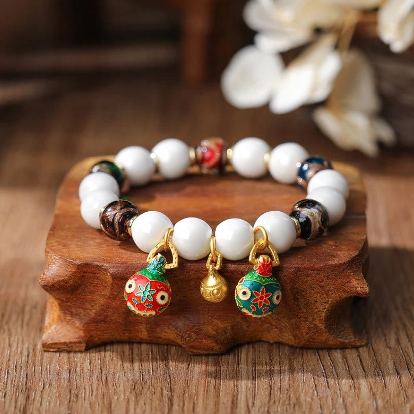 White porcelain and mixed accent beads bracelet with fish-shaped enamel pendants and gold bell charm