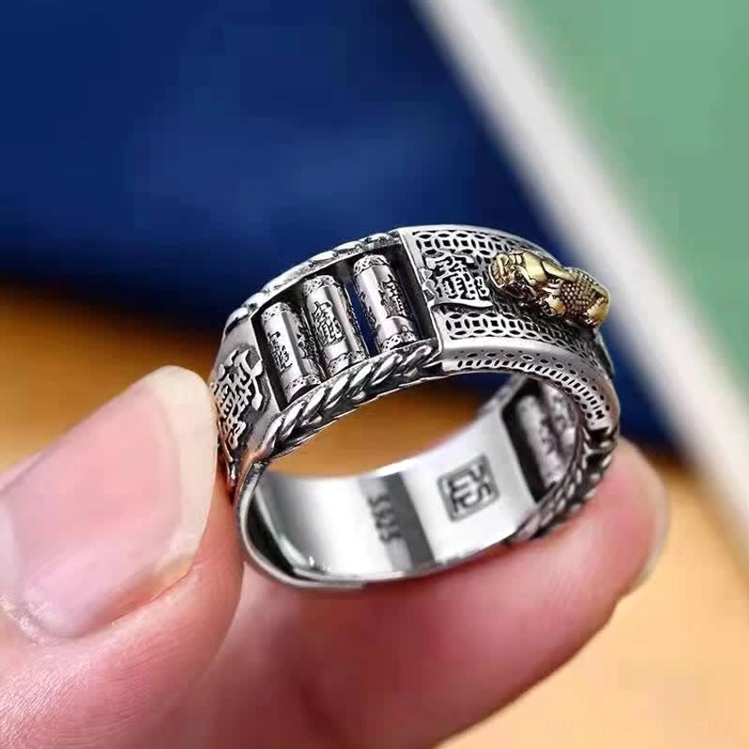 Pixiu Buddhist ring held in fingertip - close-up showing S925 inner hallmark stamp, two-tone silver and gold metal, vintage carved texture and open band