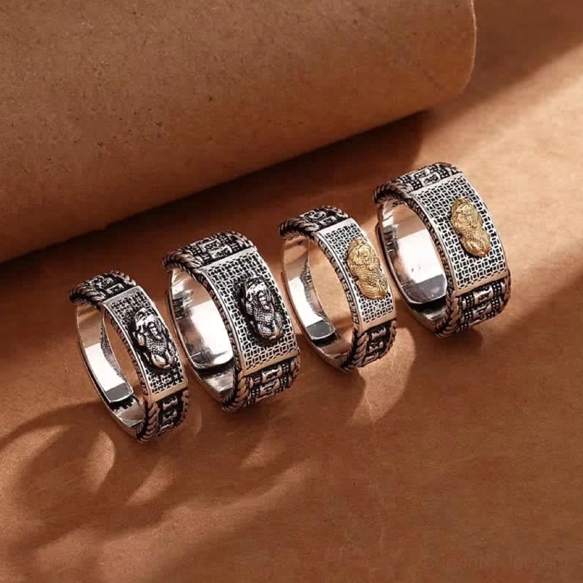 Multiple Pixiu wealth rings collection - flat lay showing mixed styles with and without gold accents, vintage silver metal, open adjustable bands on brown paper