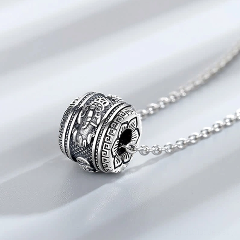 Side oblique view of Pixiu rotating pendant necklace displaying intricate traditional Buddhist carvings and twisted link chain design