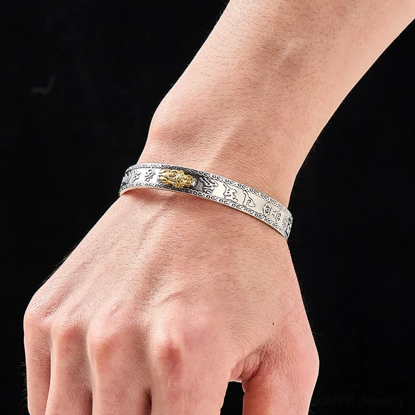 Pixiu silver bangle bracelet worn on wrist showing gold Pixiu accent and subtle engraved patterns