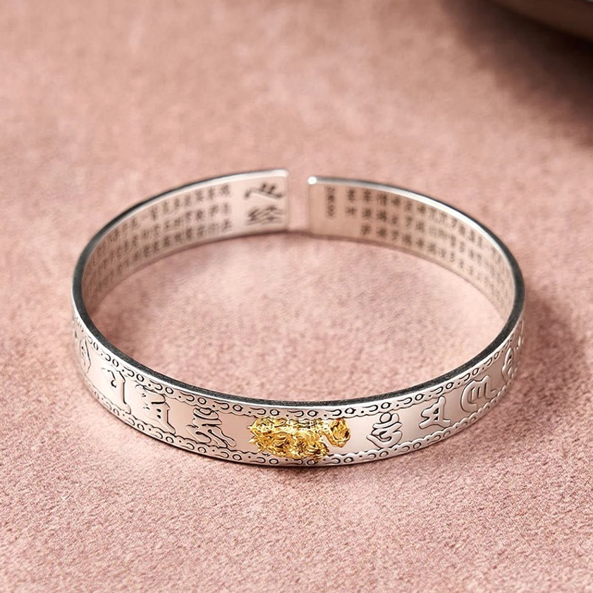 Open cuff Pixiu silver bangle bracelet top-down flat view with outer engraved patterns and central gold charm