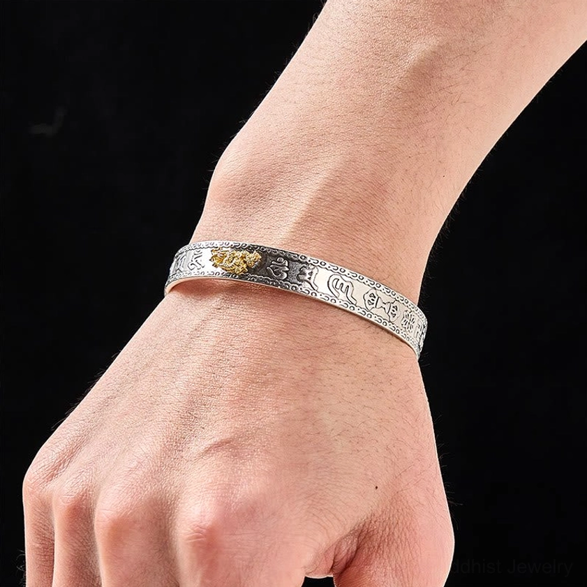 Pixiu silver bangle bracelet worn on wrist side view displaying engraved patterns and gold Pixiu detail