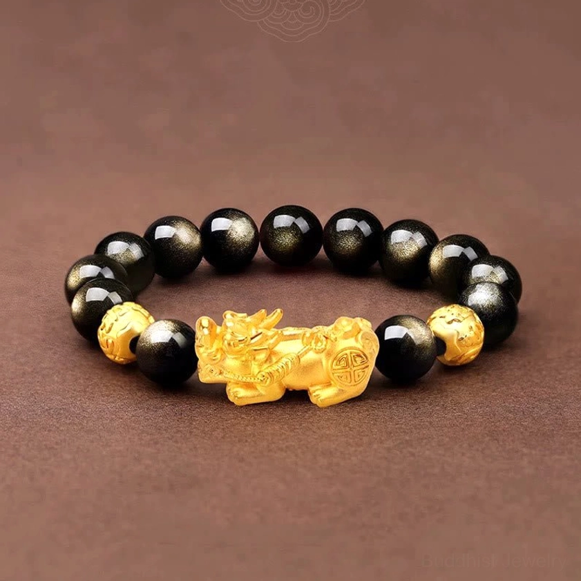 Gold sheen obsidian Pixiu bracelet overhead view with central gold charm, obsidian beads, and copper spacer accents