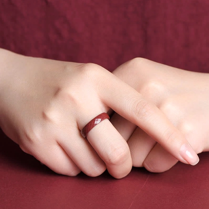 Hand model wearing plain cinnabar band ring demonstrating elegant minimal design and daily wearability for spiritual practice