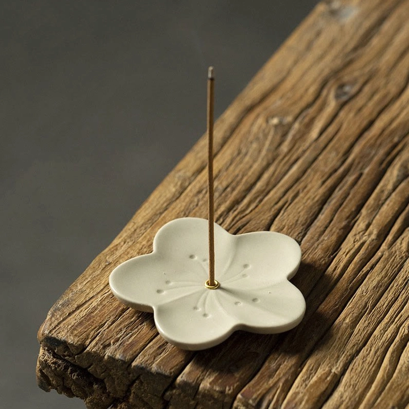 Plum blossom ceramic incense burner with dotted petal details and central metal pin