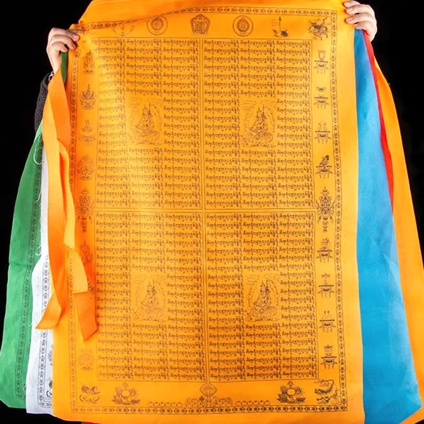 Reverse side of orange Buddhist prayer flag showing printed mantras and sacred text with colorful panels