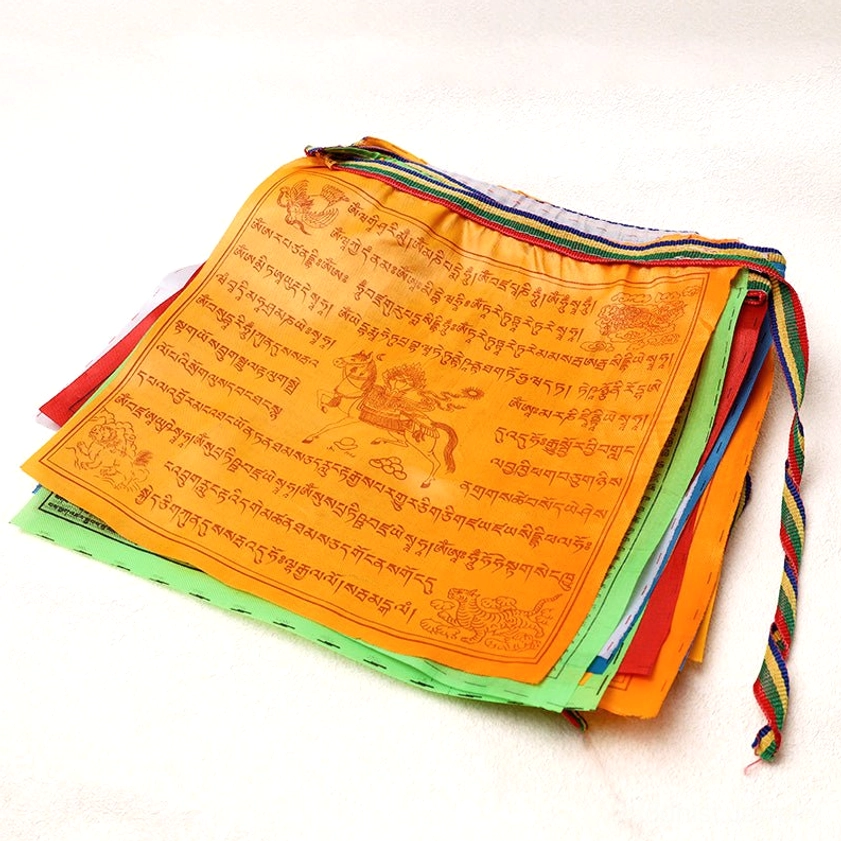 Stacked colorful Buddhist prayer flags showing multi-colored layers with striped suspension cords for outdoor hanging