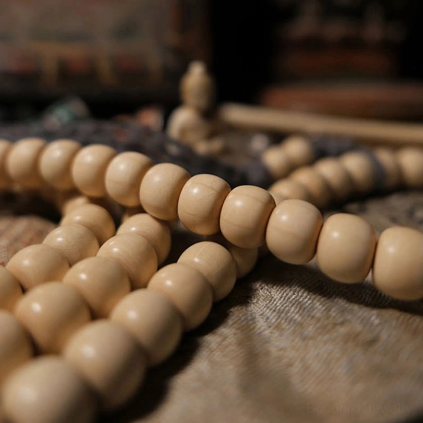 Strand of smooth creamy wooden beads with dark grey woven tassel from 108 bead prayer mala