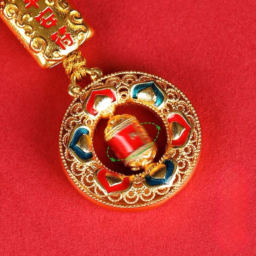Close-up of rotatable copper prayer wheel with heart-shaped enamel decoration and red rotating cylinder