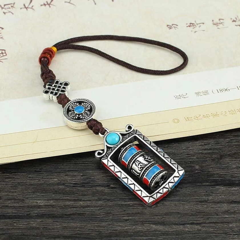 Prayer wheel keychain with blue-centered charm, silver Chinese knot, and enamel-decorated cylinder