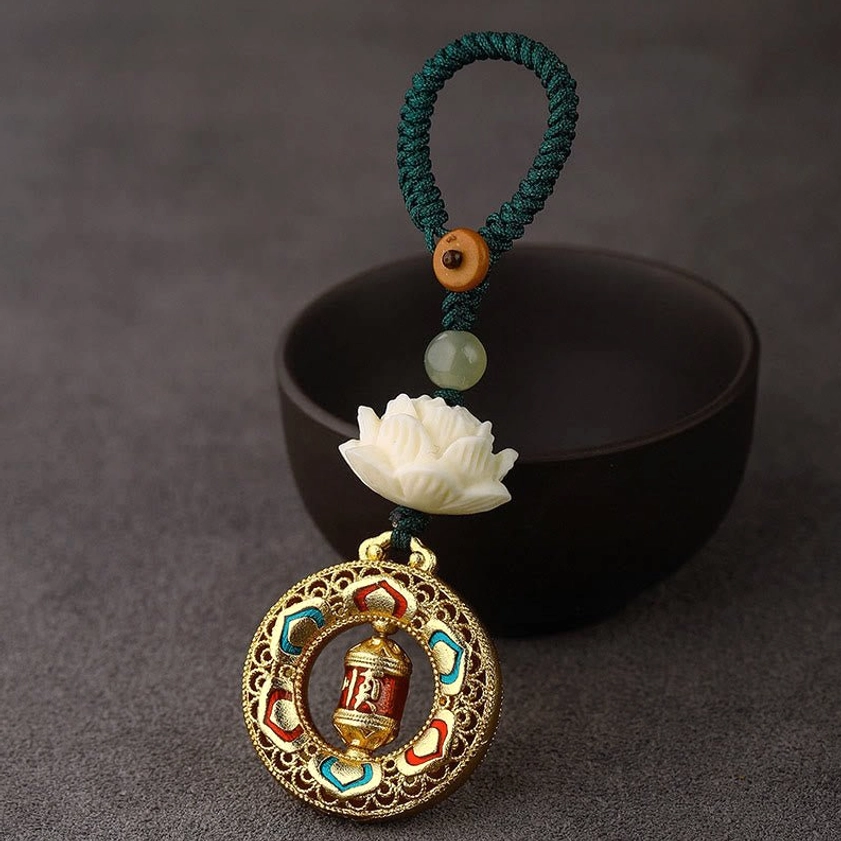 Prayer wheel keychain charm with green braided rope and rotatable copper pendant for compassion and positive intentions