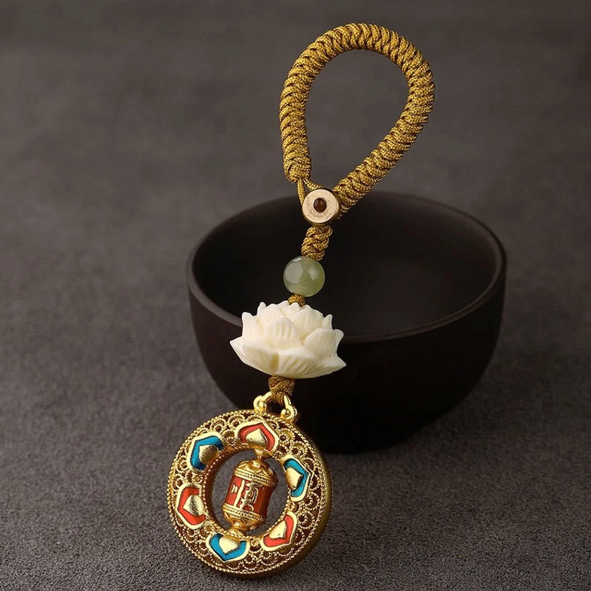 Prayer wheel design keychain with yellow braided rope and rotatable copper meditation charm for spiritual seekers