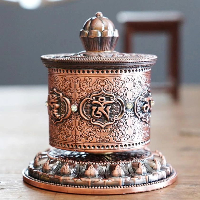 Buddhist prayer wheel showing traditional lotus crown design and intricate base craftsmanship details