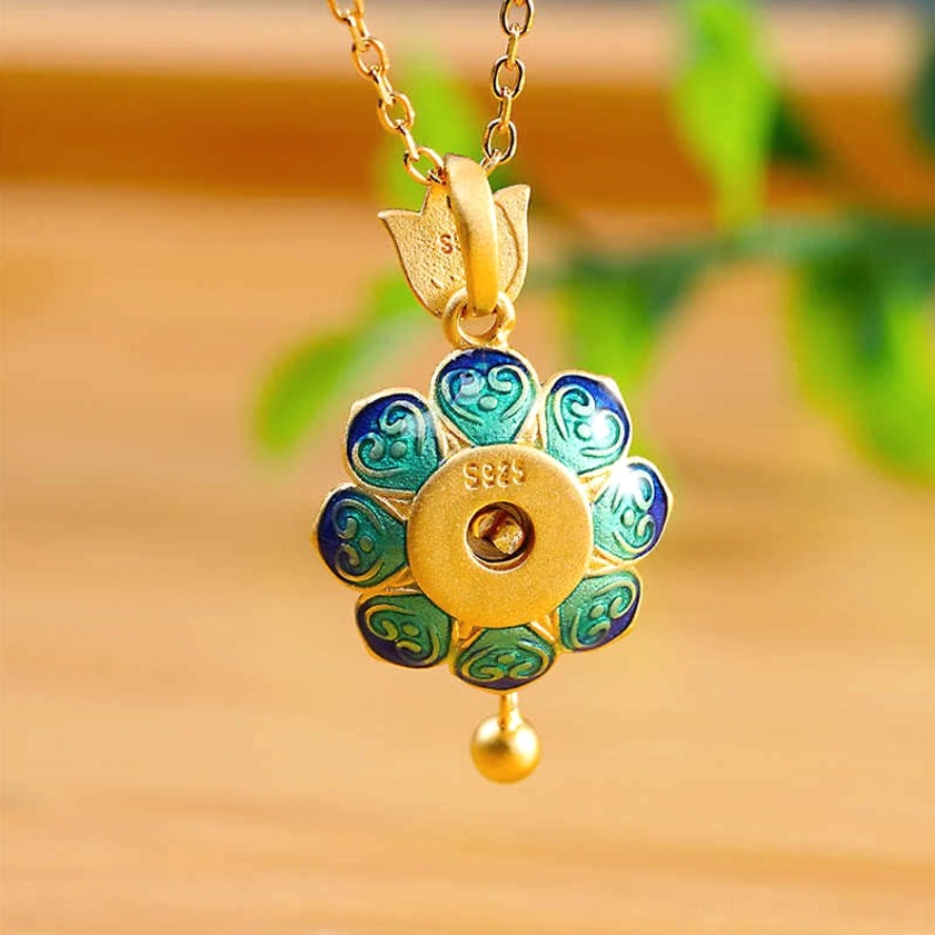 Rear view of Buddhist lotus prayer wheel pendant highlighting blue-green enamel petals and 925 sterling silver certification