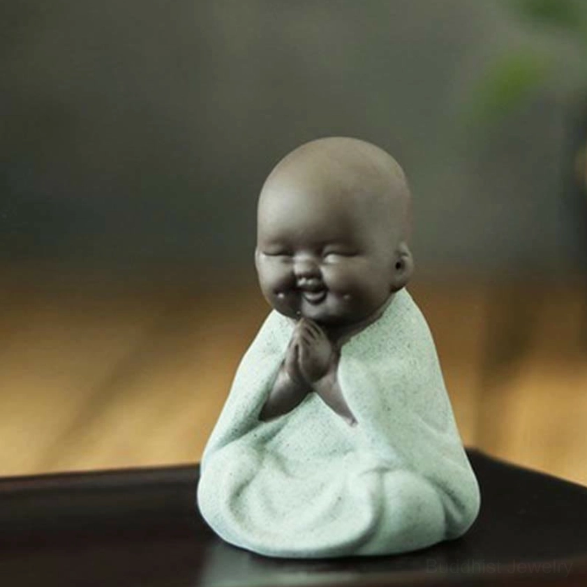 Praying green little monk statue with hands in gratitude gesture, Buddhist figurine for blessing and spiritual practice