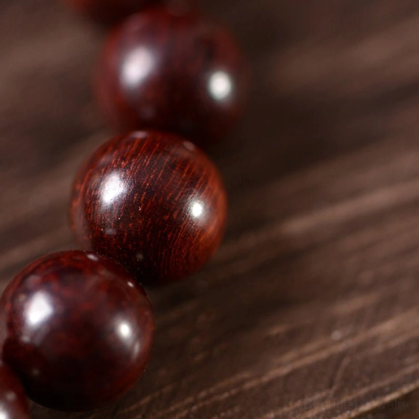 Glossy dark red sandalwood round beads with fine wood grain texture macro shot
