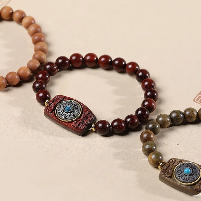 Premium sandalwood Buddhist bracelet featuring polished beads and ornate mantra charm with gemstone