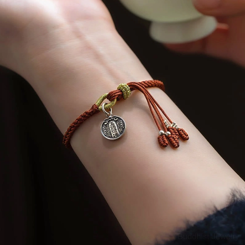 Sterling silver Five Directions Wealth Gods protection bracelet worn on wrist with dark sleeve backdrop