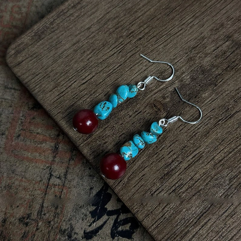 Paired symmetrical sterling silver turquoise cinnabar Buddhist protection earrings detail shot
