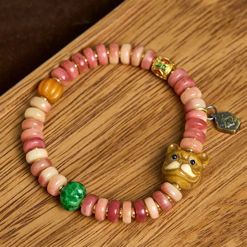Handcrafted Buddhist camel bone pug charm bracelet featuring carved pug charm, amber bead, and enamel metal accents - side angle view