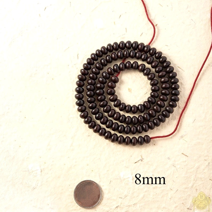 8mm purple bodhi seed mala bracelet flat lay with coin for size reference on beige paper