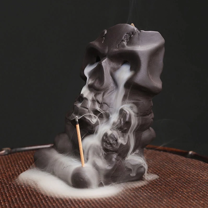 Natural purple clay skull incense holder left perspective view with cascading incense smoke
