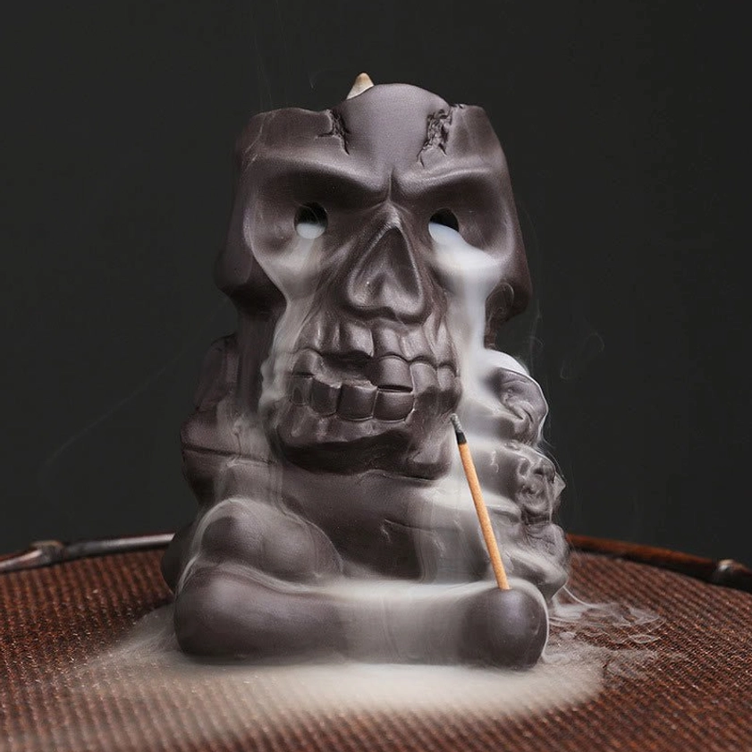 Purple clay skull backflow incense burner front view with flowing smoke and stick incense
