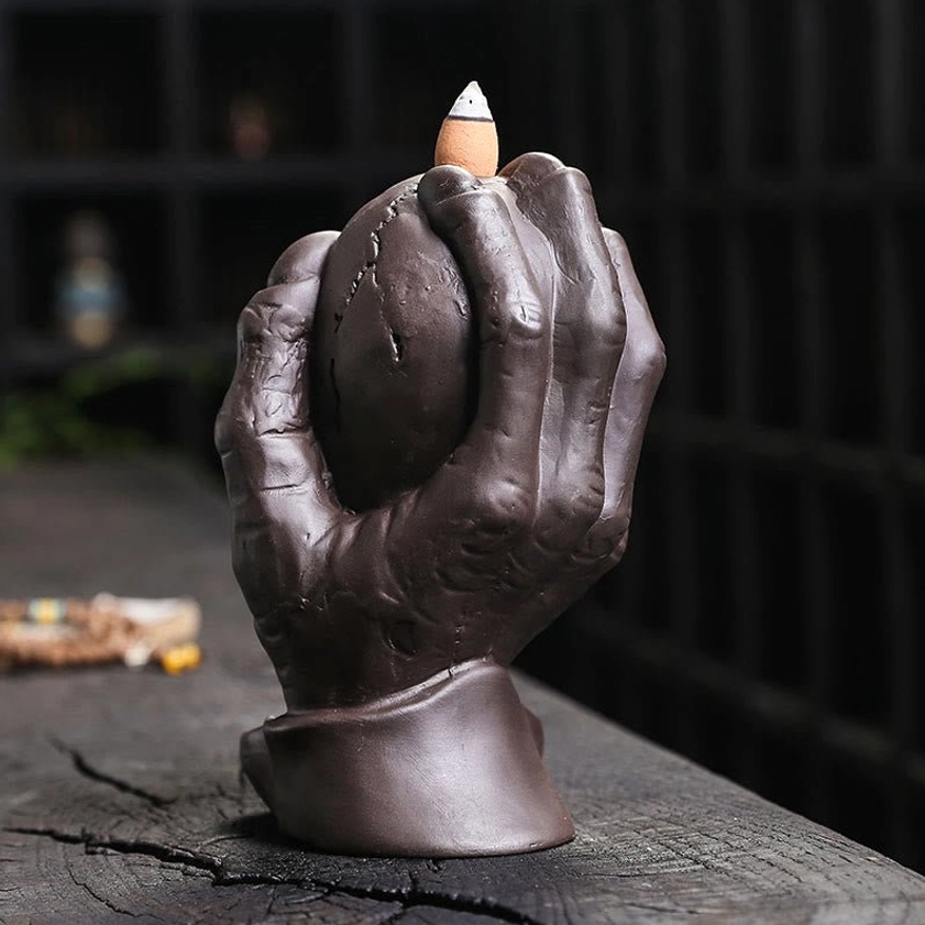 Purple clay skull incense burner with ghost hand cradling sphere - front view without active smoke