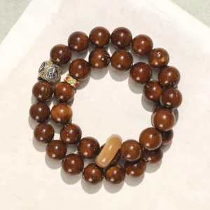 Purple Gold Rat Bodhi Seed double wrap bracelet flat lay top view with reddish-brown glossy beads and decorative metal accents