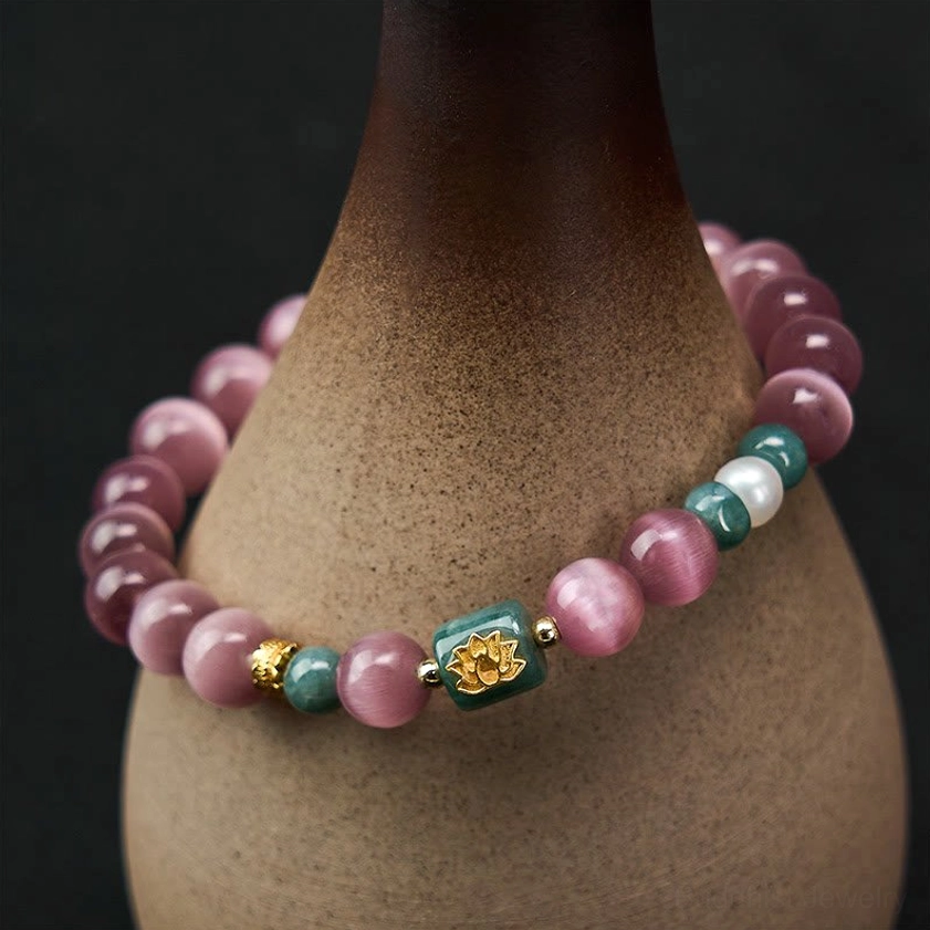 Purple cat's eye lotus bracelet front close-up neatly arranged around ceramic pottery display stand showing intricate bead work