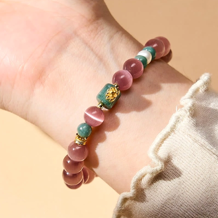 Purple cat's eye lotus bracelet worn on wrist with ruffled sweater cuff showing natural daily wear fit and comfort