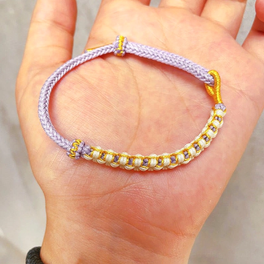 Purple handwoven peach blossom knot bracelet with gold thread worn on hand showing fit and design detail