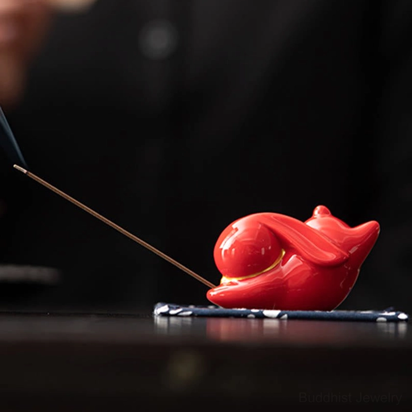 Ceramic rabbit incense burner in multiple colors with blue floral bamboo mat lifestyle setup