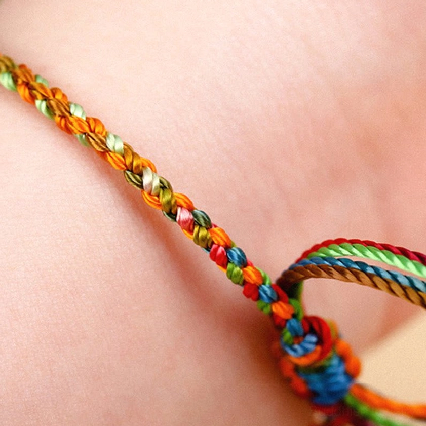 Multicolored Buddhist string bracelet on wrist showing colorful woven links and adjustable silk knot