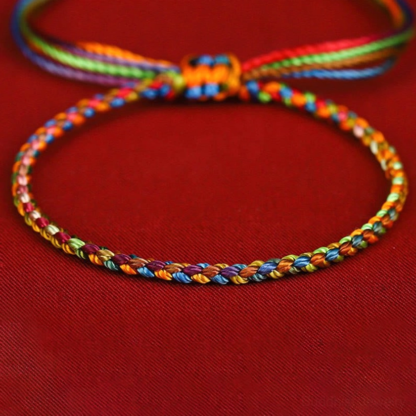 Handcrafted Buddhist string bracelet showing complete rainbow color spectrum in adjustable wrist cord design