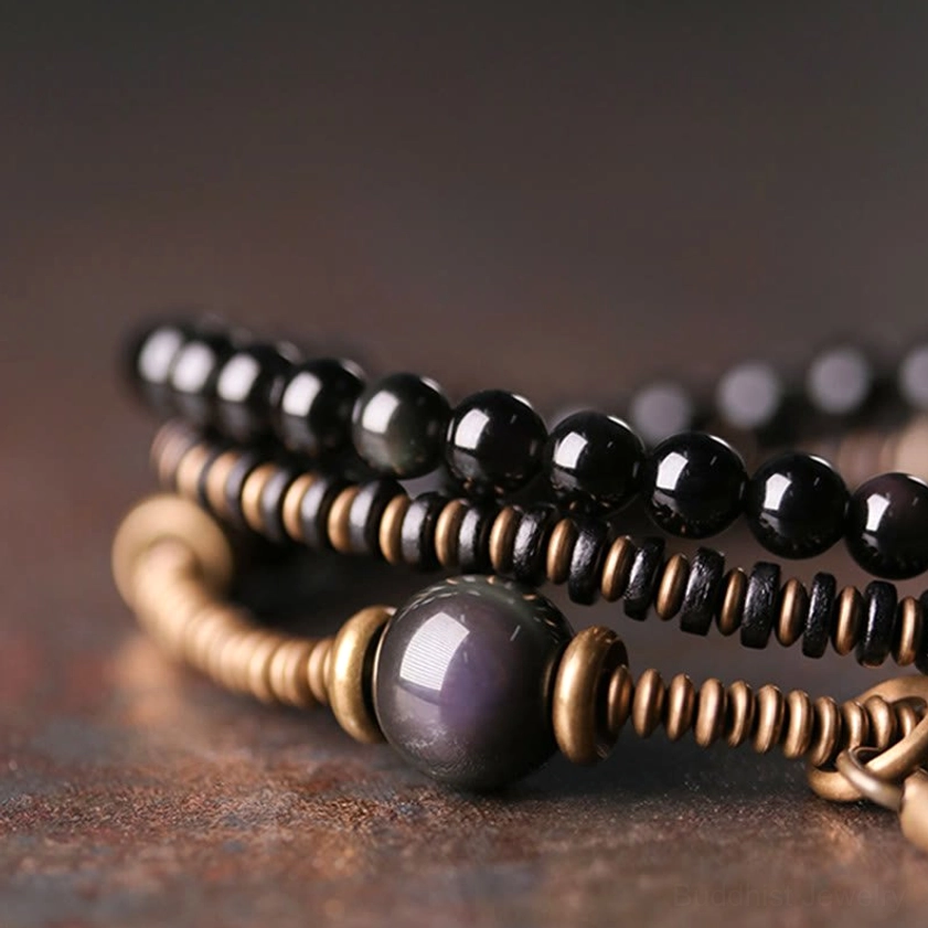 Close-up detail of iridescent rainbow obsidian bead with bronze metal spacers and wooden elements in the healing bracelet