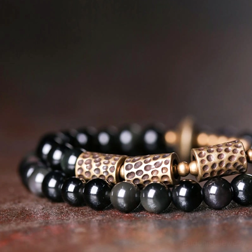 Side profile close-up of rainbow obsidian copper bracelet displaying iridescent dark bead finish and hammered bronze decorative tubes in double strand style