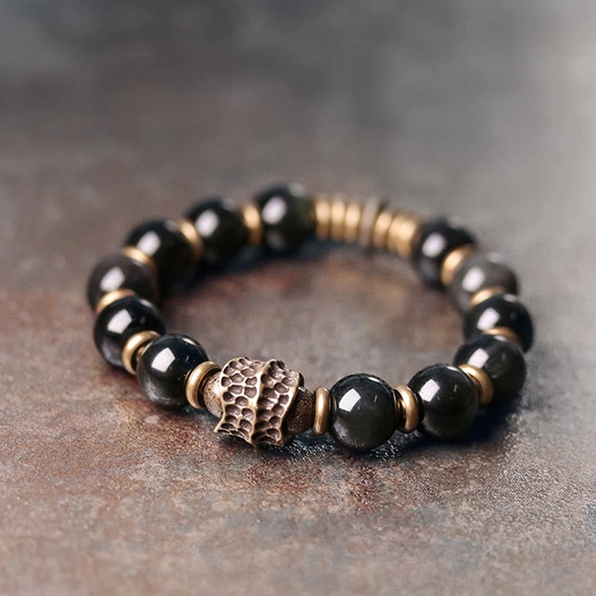 Side view of rainbow obsidian beaded bracelet showing smooth polished black beads with bronze metal accents, single-strand design for daily wear