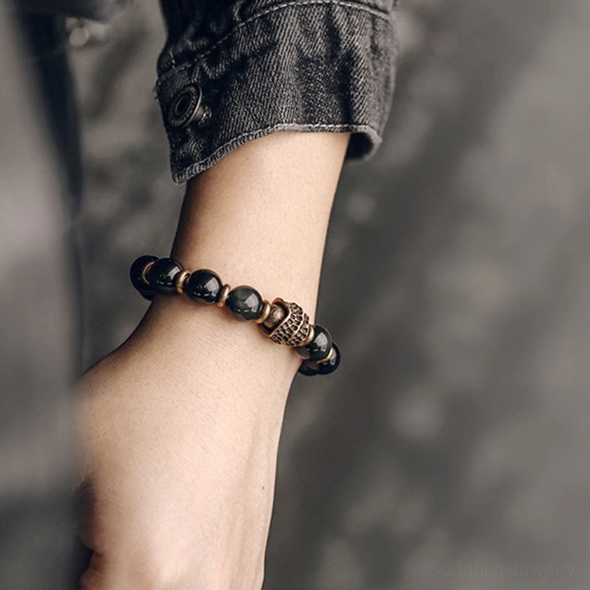 Single rainbow obsidian beaded bracelet on wrist showing comfortable elastic fit, worn with denim for minimalist spiritual accessory styling
