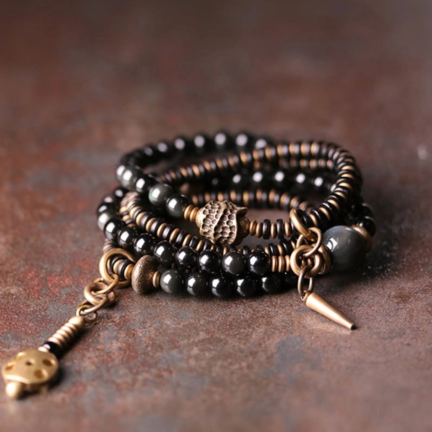 Rainbow Obsidian Ebony Wood Copper multilayer Buddhist bracelet set displayed overhead on vintage desktop with bronze hardware and tassel pendants