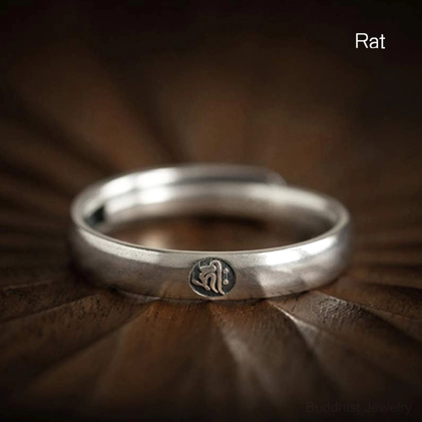 Rat zodiac natal buddha 925 sterling silver couple ring with embossed emblem, overhead dark wood background
