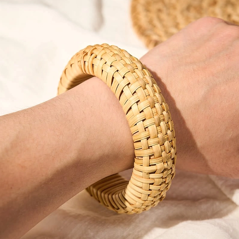 Rattan grounding bangle bracelet worn on wrist with linen fabric backdrop, bohemian wearable accessory style