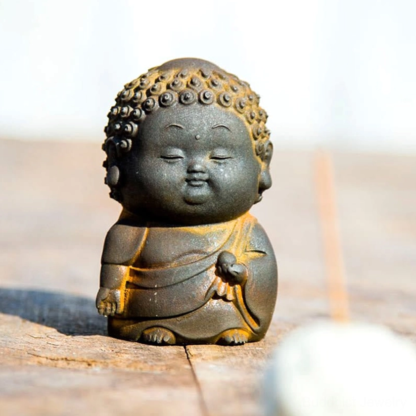 Reclining Buddha figurine 5cm size on natural wood surface representing peace and inner harmony