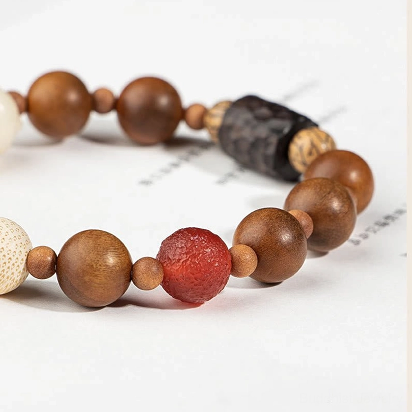 Detailed view of red agate bead and natural wood spacers on handcrafted Buddhist protection bracelet