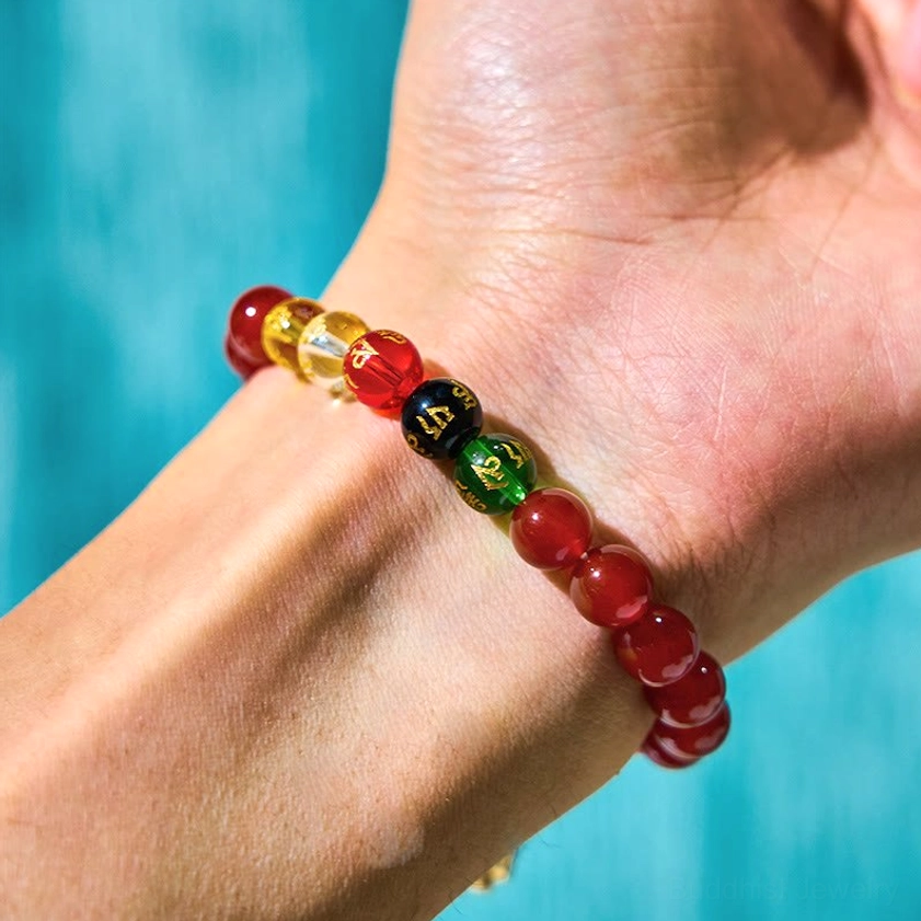 Woman wearing red agate Buddhist bracelet with colorful accent beads on wrist